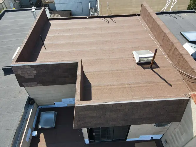 Aerial image of a clean, freshly repaired flat rooftop in San Francisco, showcasing smooth surface and professional finish